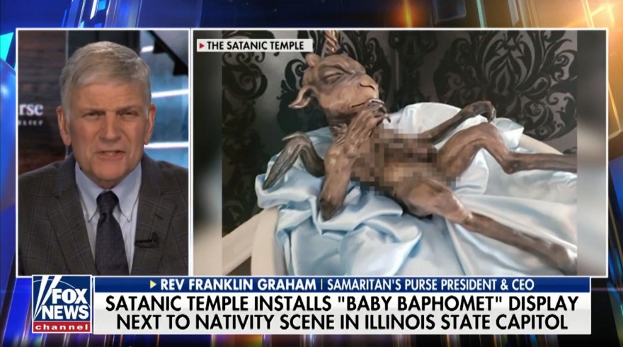 Fox news screenshot with Franklin Graham talking. Chryon: Satanic Temple installs “Baby Baphomet” display next to nativity scene in Illinois state capitol