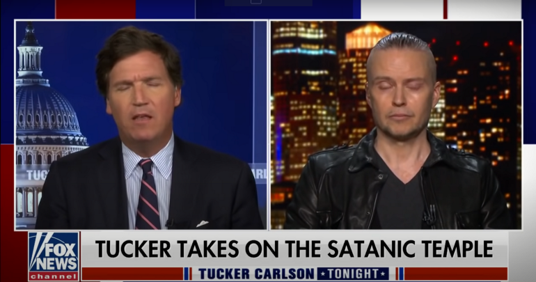 Tucker Carlson show screenshot: "Tucker takes on The Satanic Temple" with Carlson and Lucien Greaves (Doug Misicko)